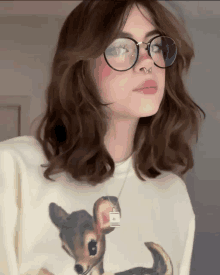 a girl wearing glasses and a necklace with a deer on it