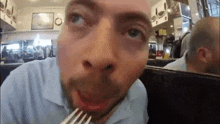 a man is eating a meal with a fork in his mouth .