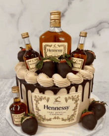 a cake with a bottle of hennessy and chocolate covered strawberries