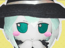 a stuffed witch with green eyes and a black hat