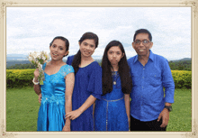 a group of people posing for a picture with one girl holding flowers