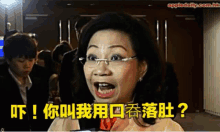 a woman with glasses is talking into a microphone with chinese writing on the bottom right