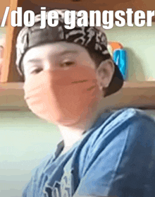 a young boy wearing a bandana and a mask with the words / do-je-gangster written above him