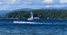 a sailboat and a jet ski are floating on a lake