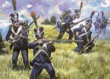 a group of soldiers are kneeling in a field holding guns .