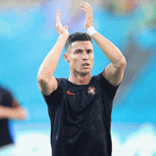 a soccer player wearing a black nike shirt applauds