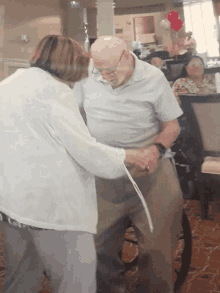 a man in a wheelchair is being helped by a woman in a white shirt