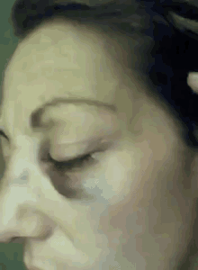 a close up of a woman 's face with a black spot on her forehead