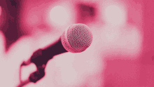 a close up of a pink microphone with a pink background