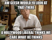 a man is sitting at a table with a book in his hand and a hollywood liberal thinks he cares what he thinks .