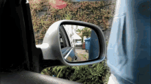 a car 's rear view mirror shows a white car