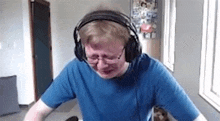 a man wearing headphones and glasses is crying in a room .