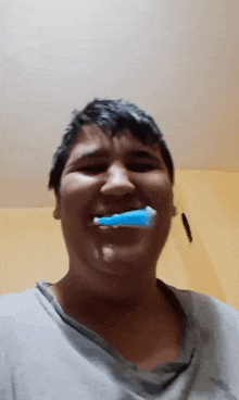 a man is brushing his teeth with a blue brush