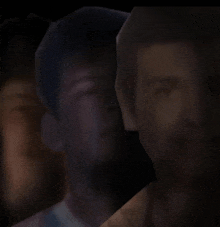 a blurred image of a man 's face with a dark background