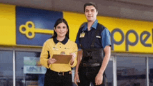 a man and a woman are standing in front of a store with a key on the wall .