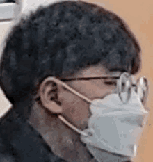 a man wearing a face mask and glasses is looking at the camera .