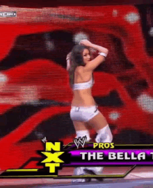 a woman is dancing in front of a screen that says nxt pro the bella