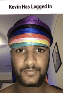 a man with a beard wearing a rainbow headband with the words kevin has logged in above him .