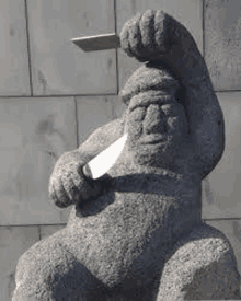 a statue of a man with a beard holding a knife in his hand .