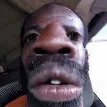 a close up of a man 's face with a beard and a tooth missing .