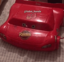 a red toy car with the number 69 on the back