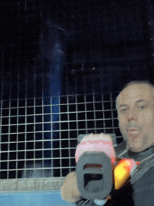 a man with a beard holds a toy gun with the number 10 on it