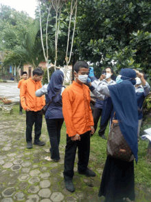 a group of people wearing face masks are standing in a row