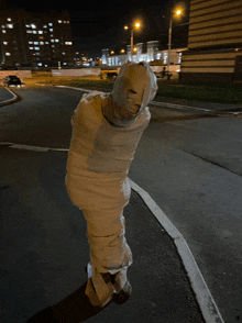 a person wrapped in a mummy costume is standing on a street