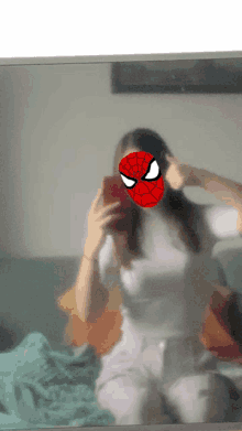 a woman wearing a spiderman mask takes a selfie