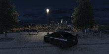 a black car is parked in a park with a view of the city at night