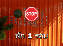 a stop sign is on a wall with stickers on it