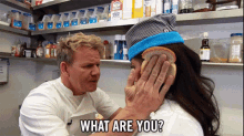 a man covering a woman 's ear with a piece of bread and the words " what are you " on the bottom