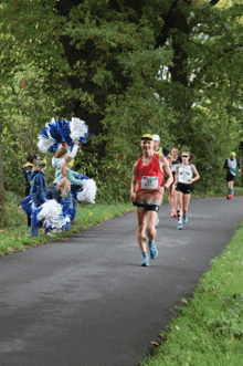 a group of runners are running down a path and one of them is wearing a shirt that says ' smith ' on the front