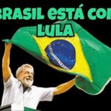 a man with a beard is holding up a green and yellow flag with the word brasil on it .