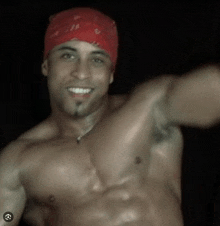 a shirtless man wearing a red bandana on his head