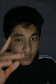 a young man is making a peace sign with his finger