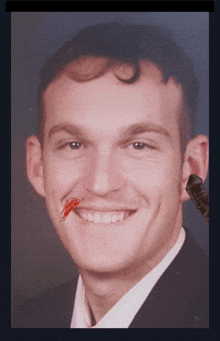 a close up of a man with a red bug in his mouth