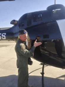 a man stands in front of a black helicopter with the letters ss on it