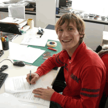 a man wearing a red shirt that says norway is smiling