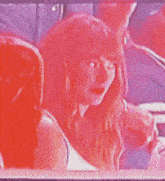 a woman with red hair is sitting in a chair with a man behind her
