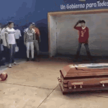 a group of people standing around a coffin with a sign that says un gobierno para todos in the background