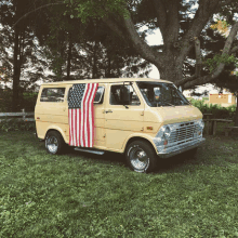 a yellow van with an american flag draped over the door