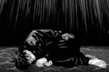 a black and white drawing of a man laying on the floor .