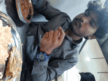 a man wearing a blue watch eating food