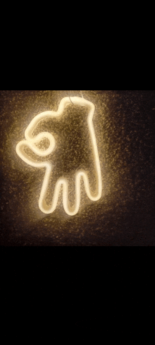 a neon sign in the shape of a cat is lit up on a wall