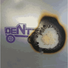 a purple dent logo with a burnt hole in the middle of it