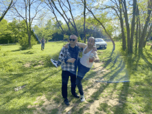 a man in a plaid shirt holds another man in a white tank top