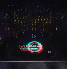 a large screen displays the galaxy nightclub logo