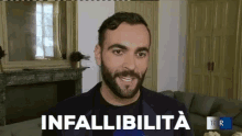 a man with a beard is standing in front of a couch with the word infallibilita written on it