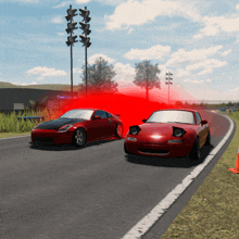 two red sports cars are driving down a road with a red light behind them